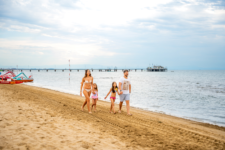 Una famiglia passeggia su una spiaggia del Friuli Venezia Giulia