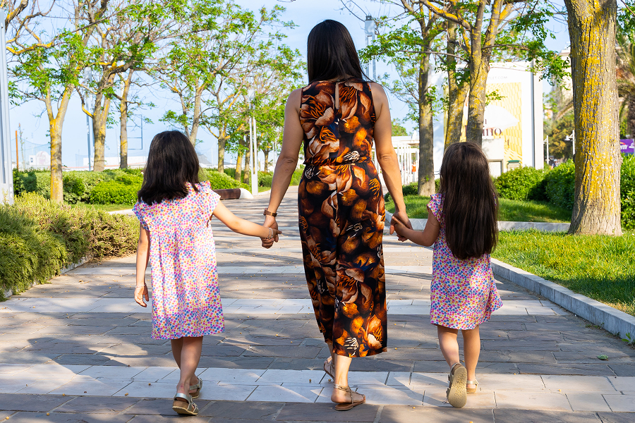 Una mamma passeggia con le sue bambine sul lungomare di Riccione